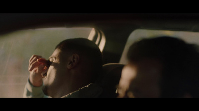 a man sitting in the back seat of a car drinking from a cup