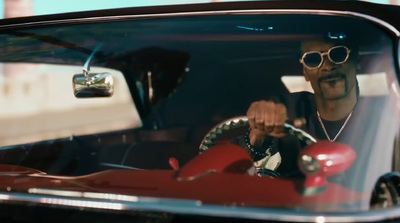 a man in sunglasses driving a red car