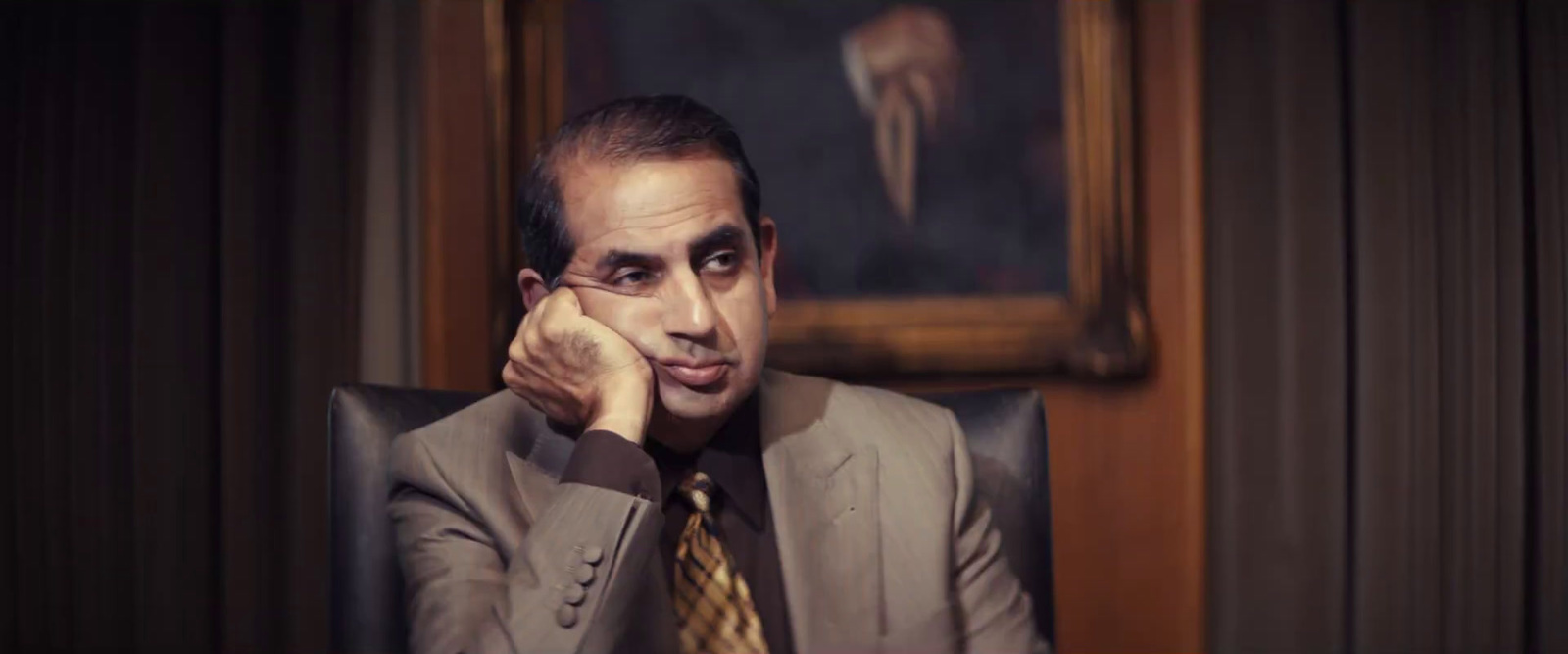 a man in a suit and tie sitting in a chair