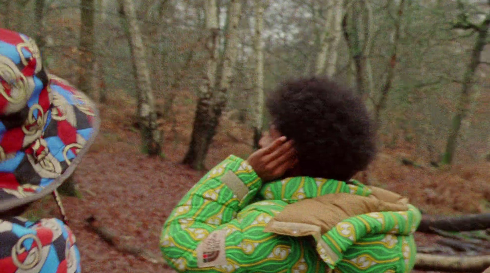 a young person standing in the woods with a frisbee