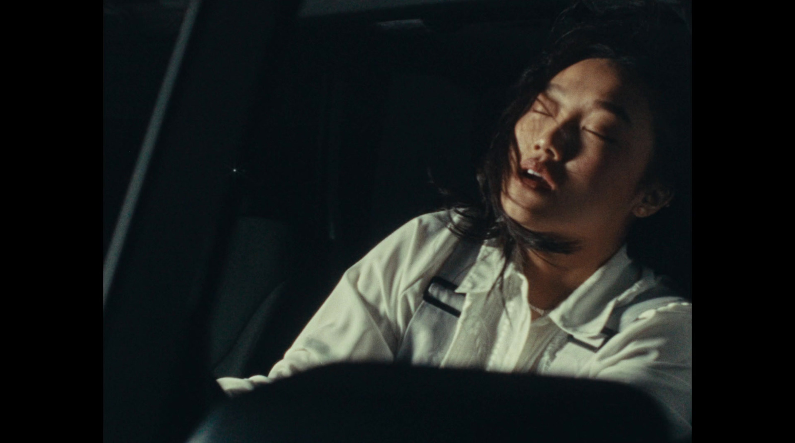 a woman sitting in a car with her eyes closed