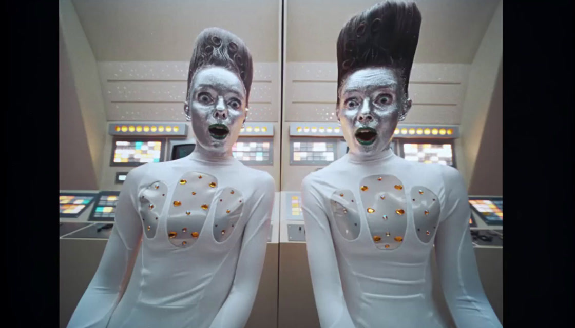 two mannequins dressed in white with silver paint on their faces