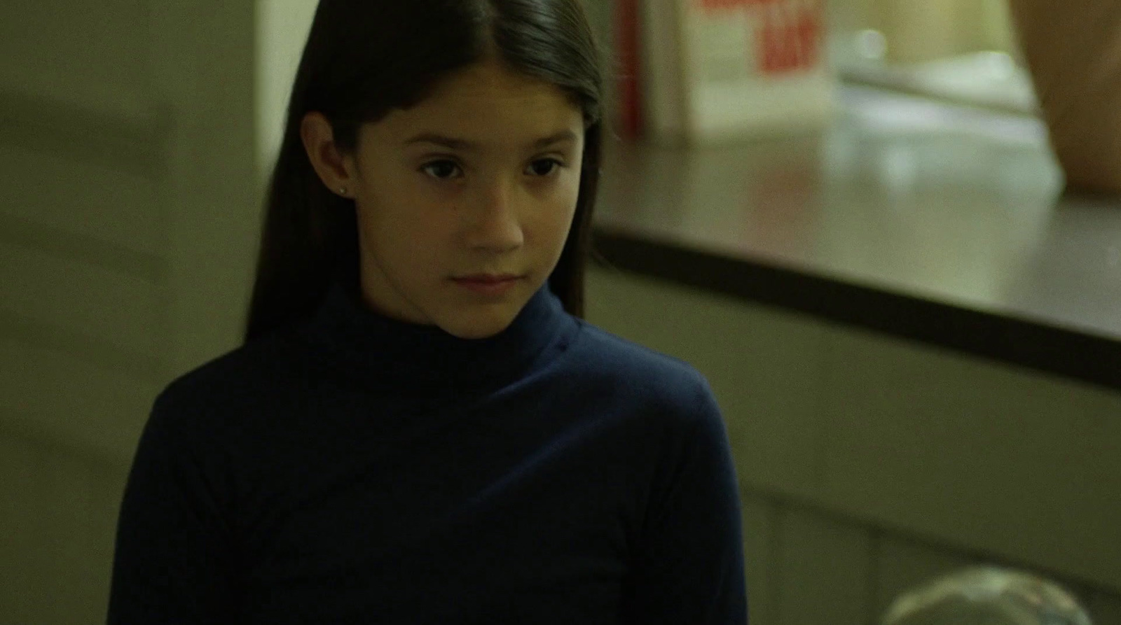 a young girl standing in a kitchen next to a counter