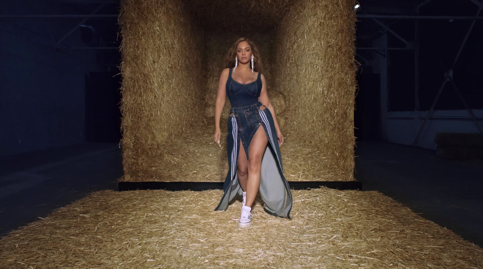 a woman in a blue dress walking down a runway