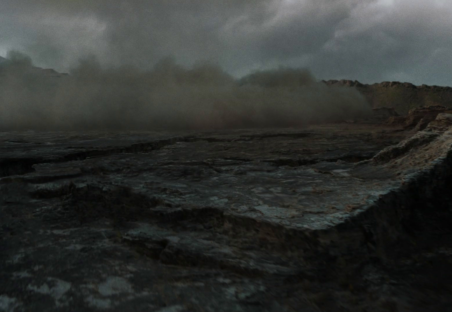 a very dark and cloudy sky over some rocks