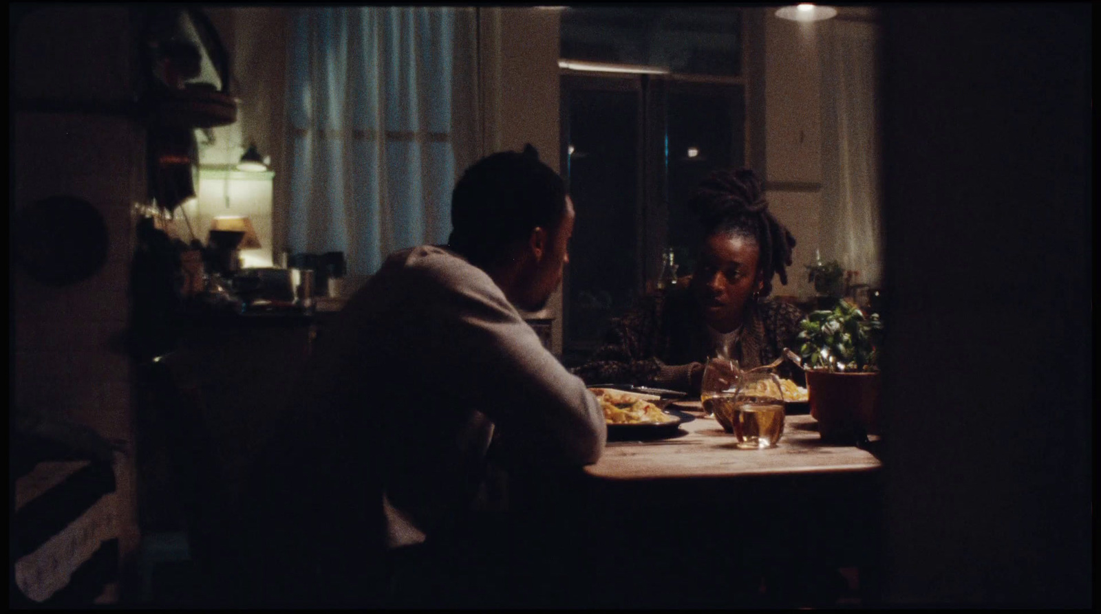 a man and a woman sitting at a table in a dark room