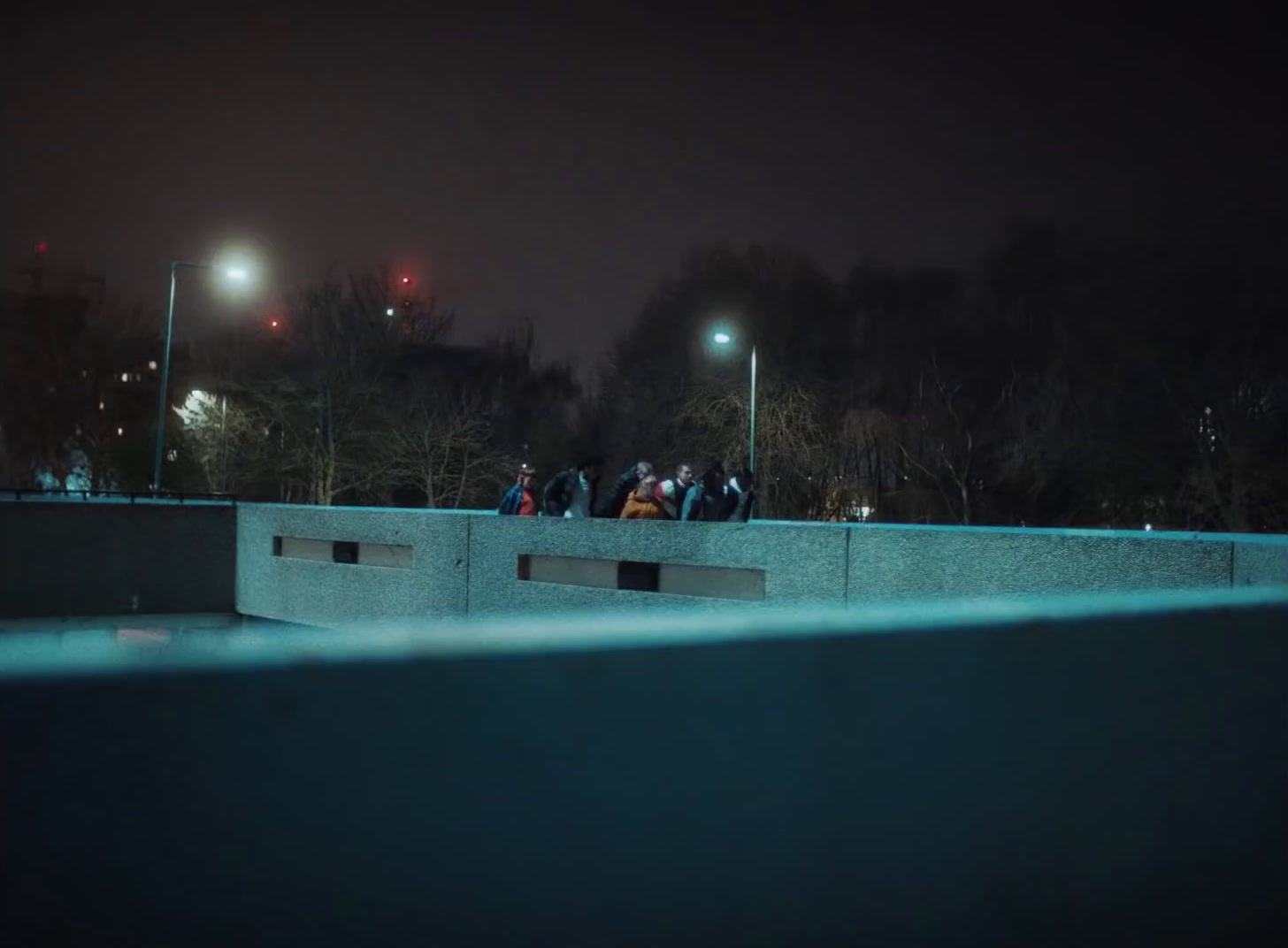 a group of people standing on top of a cement wall