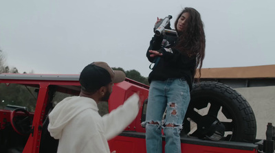 a woman standing next to a man in front of a red truck