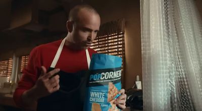 a man holding a bag of white cheddar