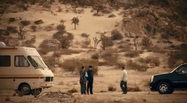 a group of people standing next to a van in the desert