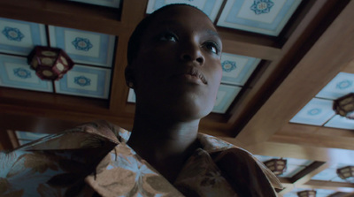 a woman standing in a room with decorative ceiling tiles