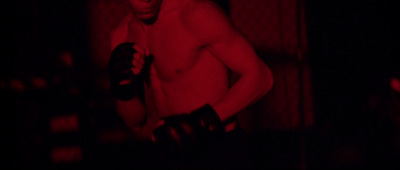 a shirtless man holding a pair of gloves