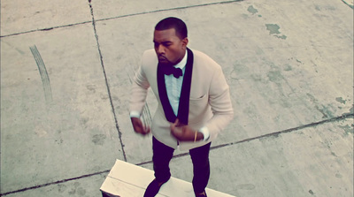 a man in a tuxedo and bow tie standing next to a box