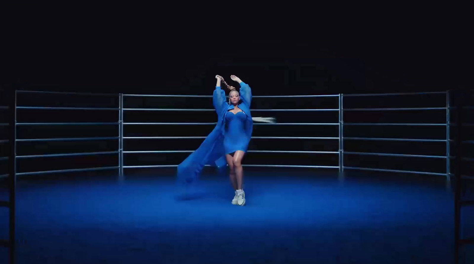 a woman in a blue dress standing in a ring