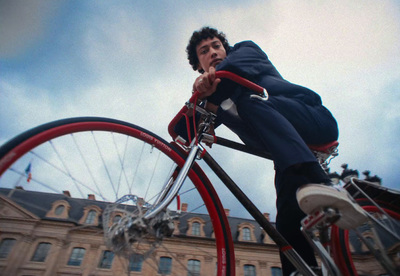 a man riding on the back of a red bike