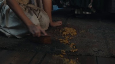 a woman sitting on the floor peeling food