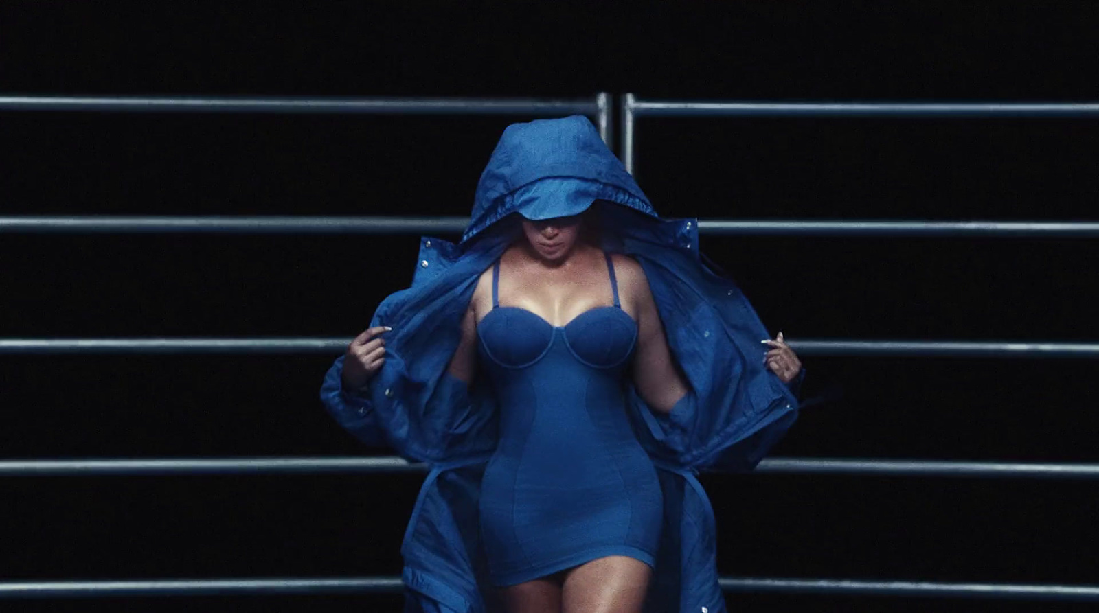 a woman in a blue dress and a blue raincoat