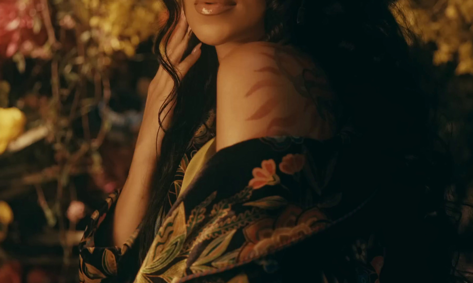 a woman with long dark hair wearing a floral dress