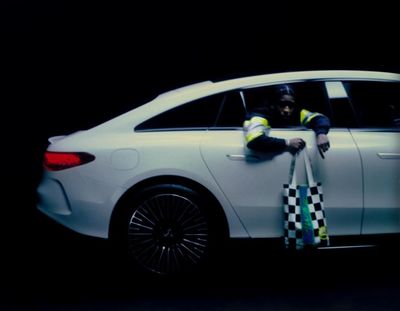 a man sitting in a car with a checkered flag