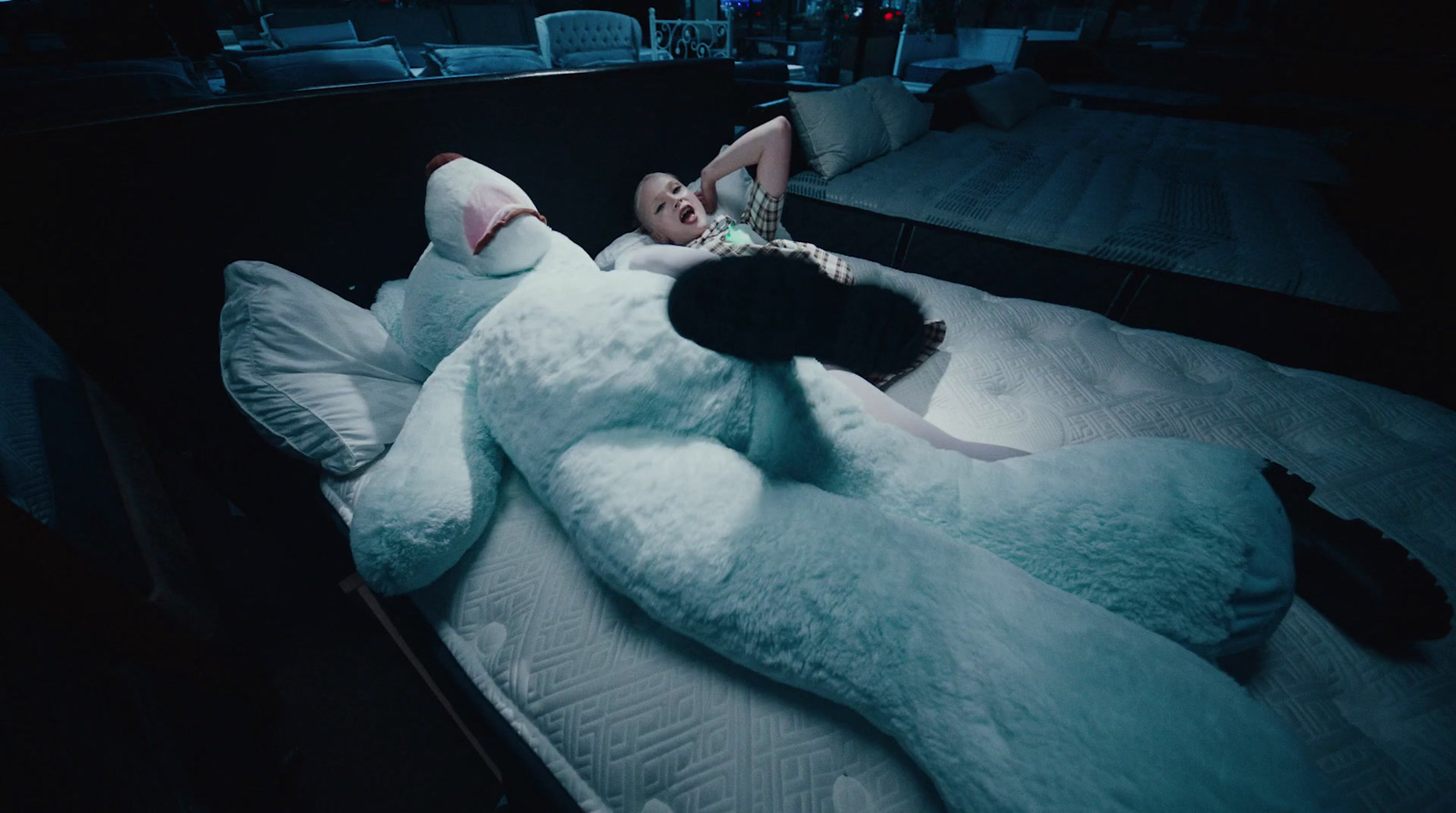 a person laying on a bed with a large stuffed animal