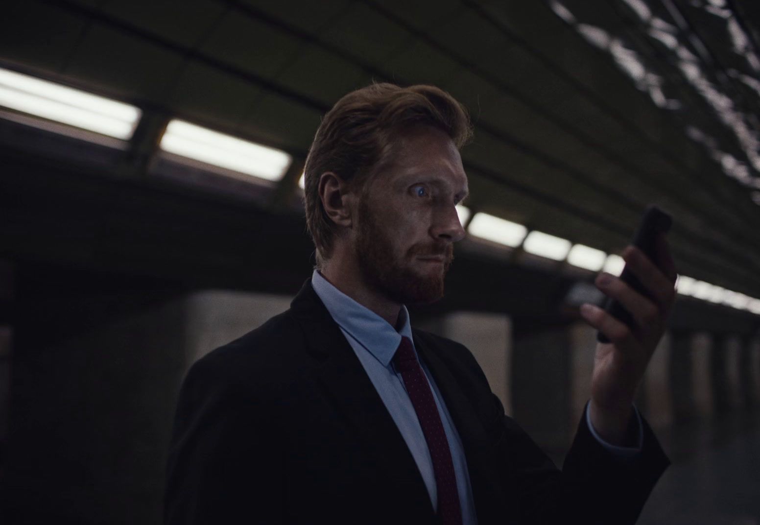 a man in a suit and tie holding a cell phone