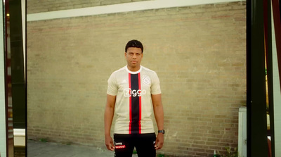 a man standing in front of a brick wall