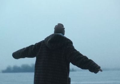 a man standing in front of a body of water