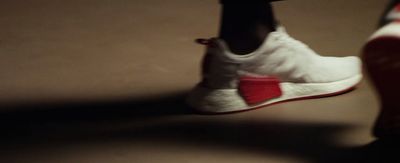 a close up of a person's white and red sneakers