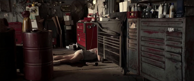 a man laying on the floor of a garage