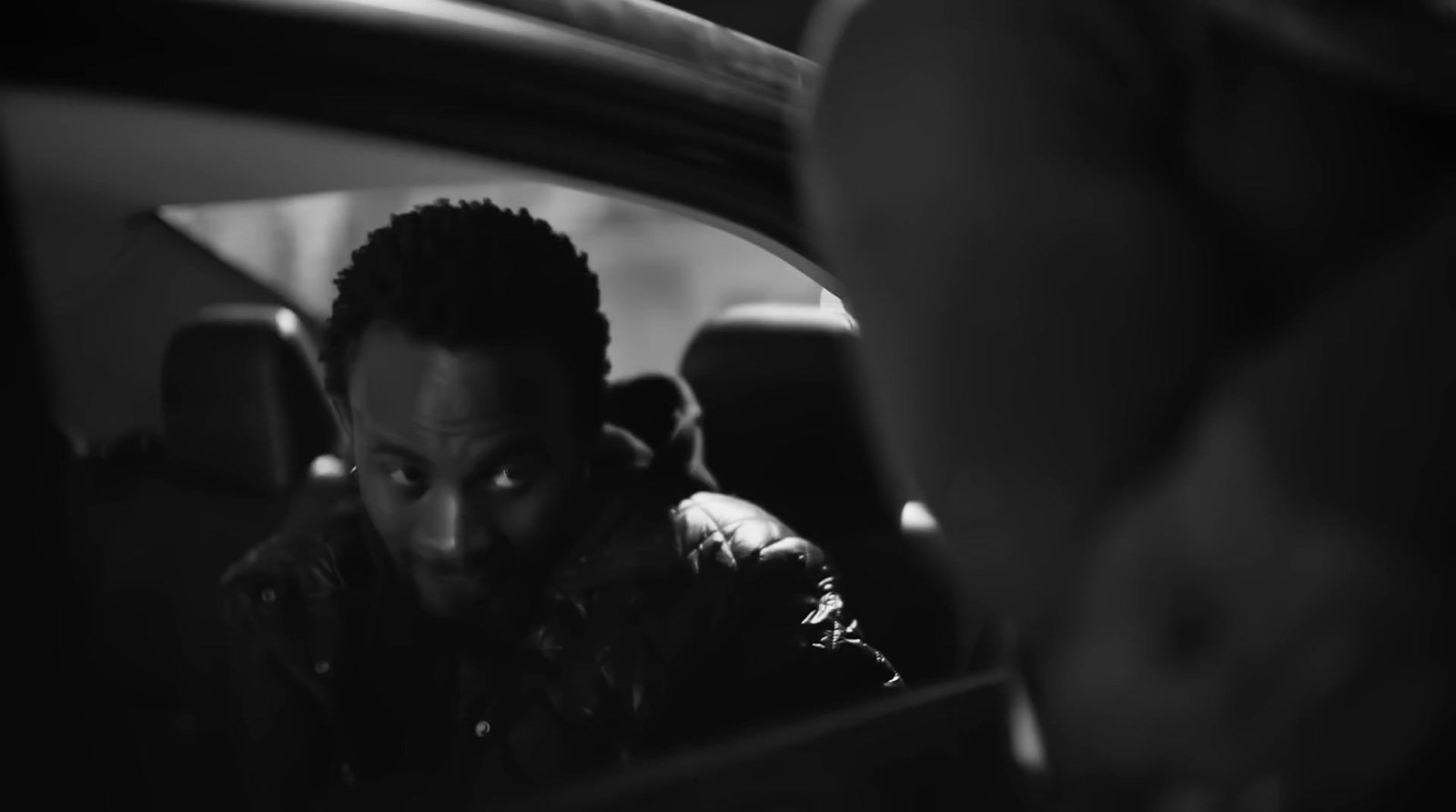 a man sitting in a car looking at his cell phone