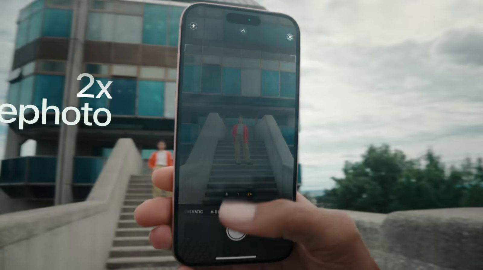 a person holding up a cell phone in front of a building