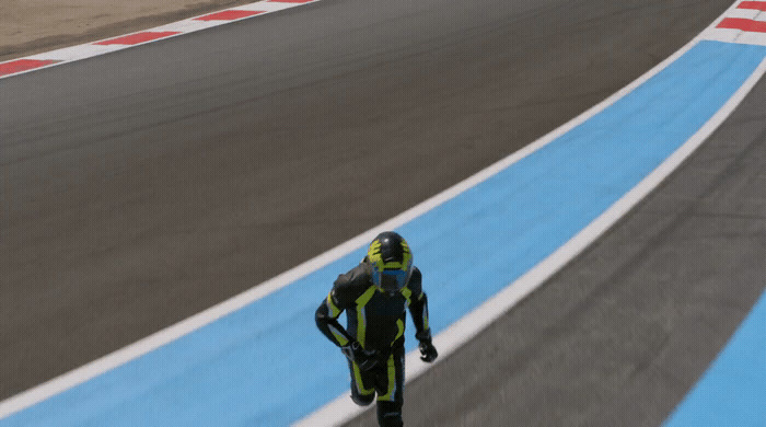 a man in a yellow and black racing suit on a race track