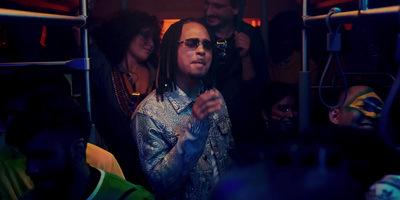 a man with dreadlocks standing in front of a group of people