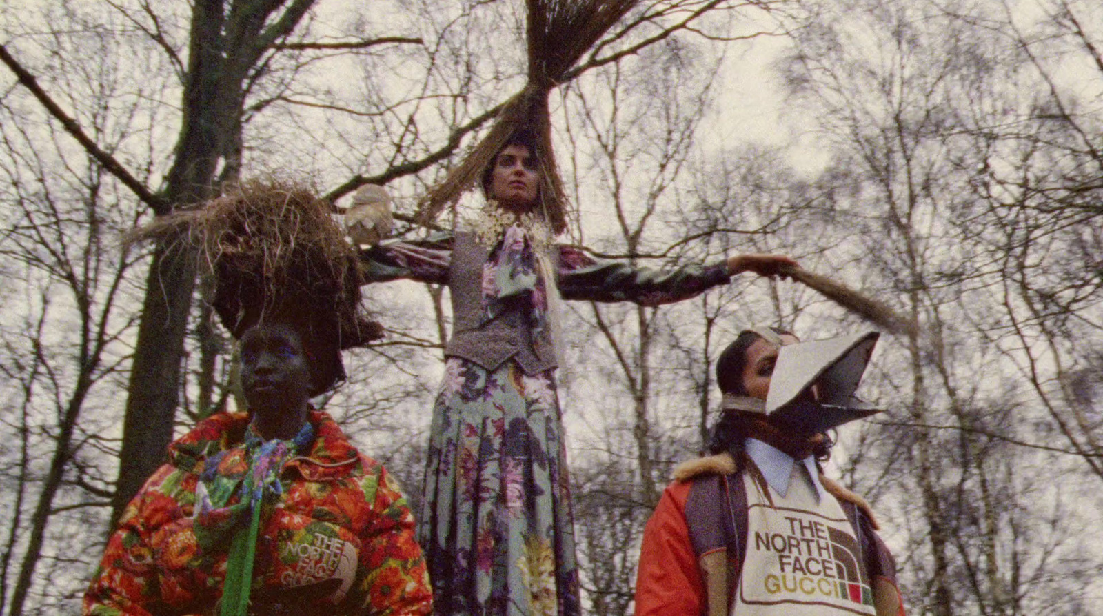 a group of people standing around each other in the woods