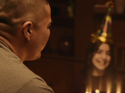 a man looking at a woman with candles in front of him