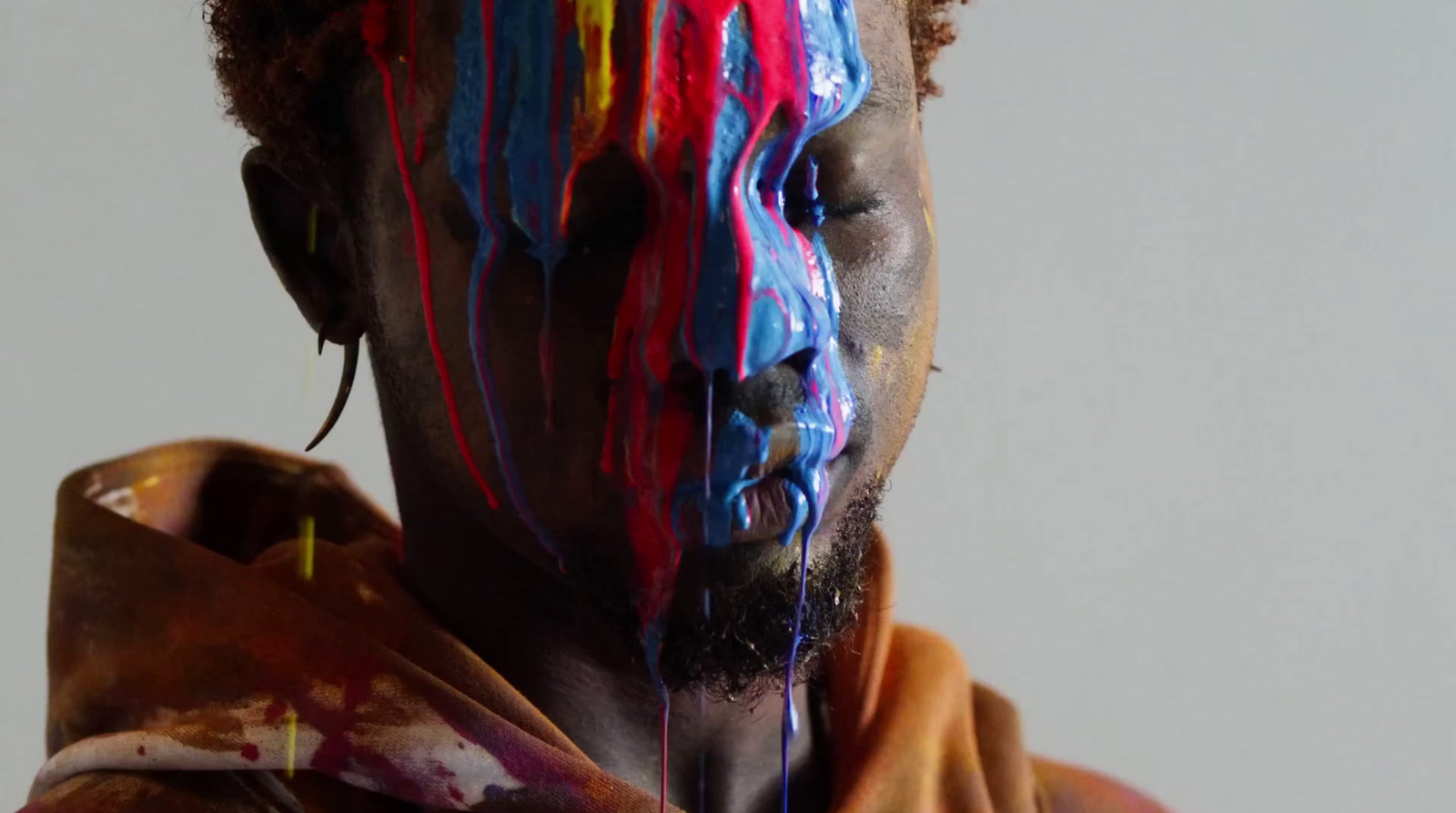 a man with his face painted with multicolored paint