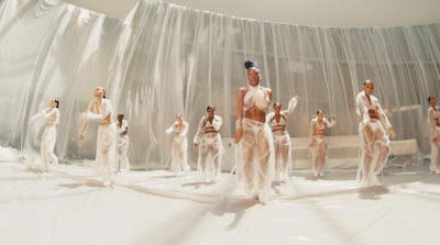 a group of naked women standing in front of a curtain