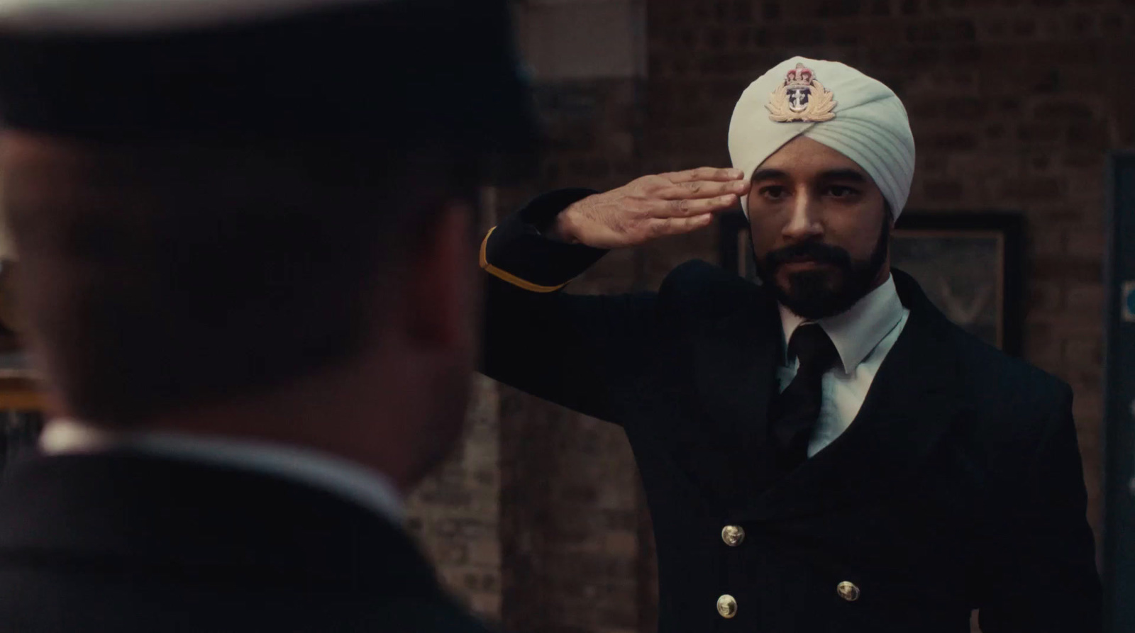 a man in a turban saluting a man in a suit