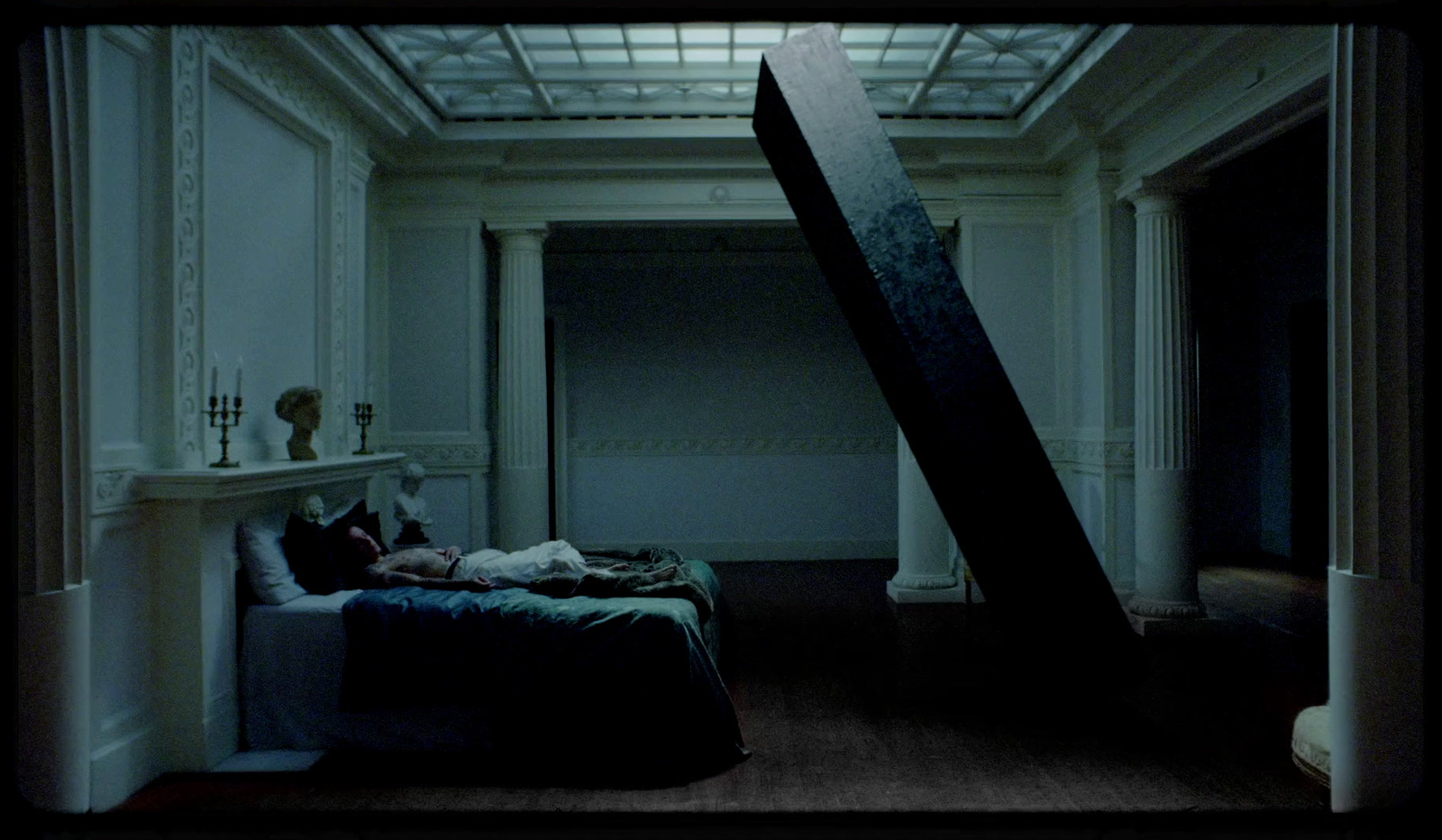 a person laying on a bed in a dimly lit room