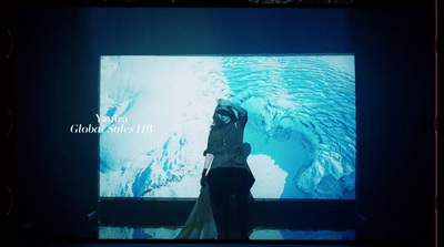 a woman standing in front of a large screen