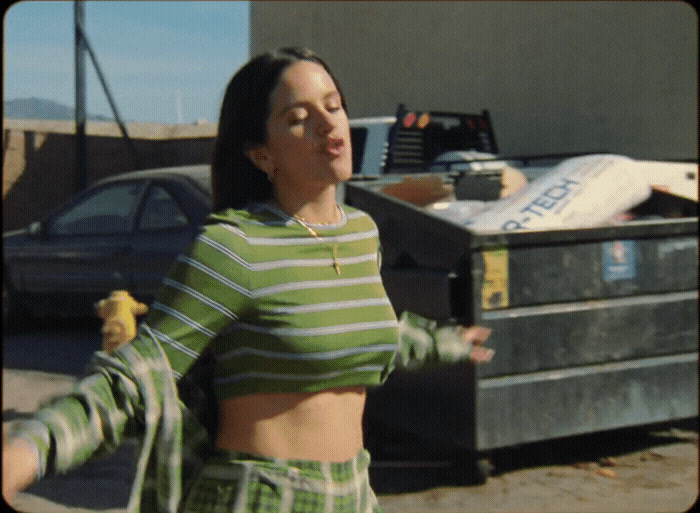 a woman standing next to a dumpster holding a banana