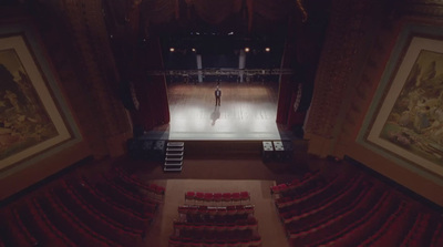 a person standing on a stage in a theater