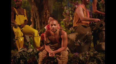 a group of men sitting on top of a lush green forest