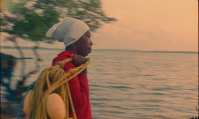 a man with a white turban is standing by the water