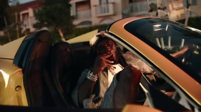 a man sitting in a car talking on a cell phone