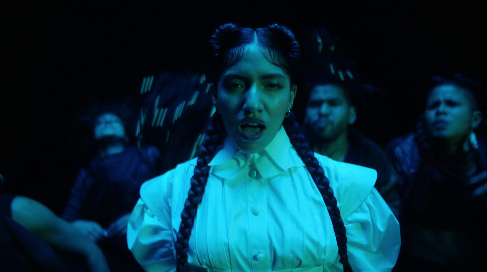 a woman with braids standing in front of a group of people