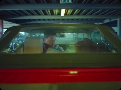 a man driving a car in a parking garage