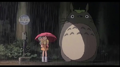 a woman holding an umbrella standing next to a totoro