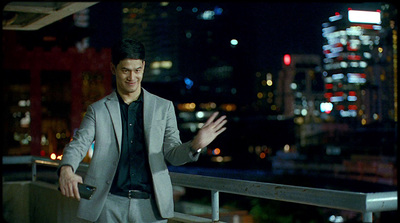 a man in a suit standing on a balcony