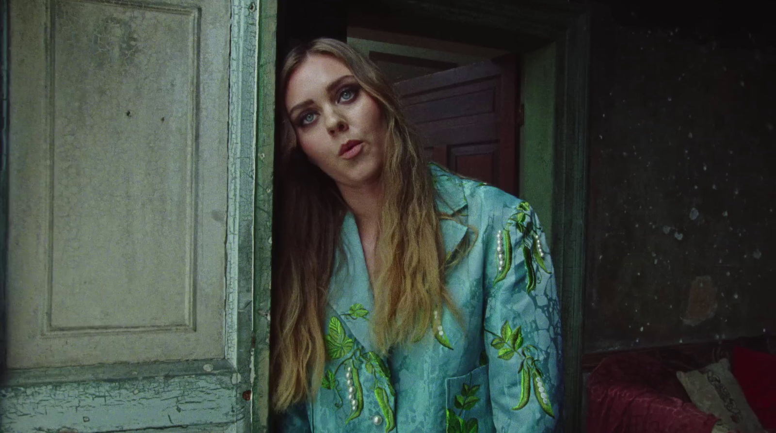 a woman with long hair standing in a doorway